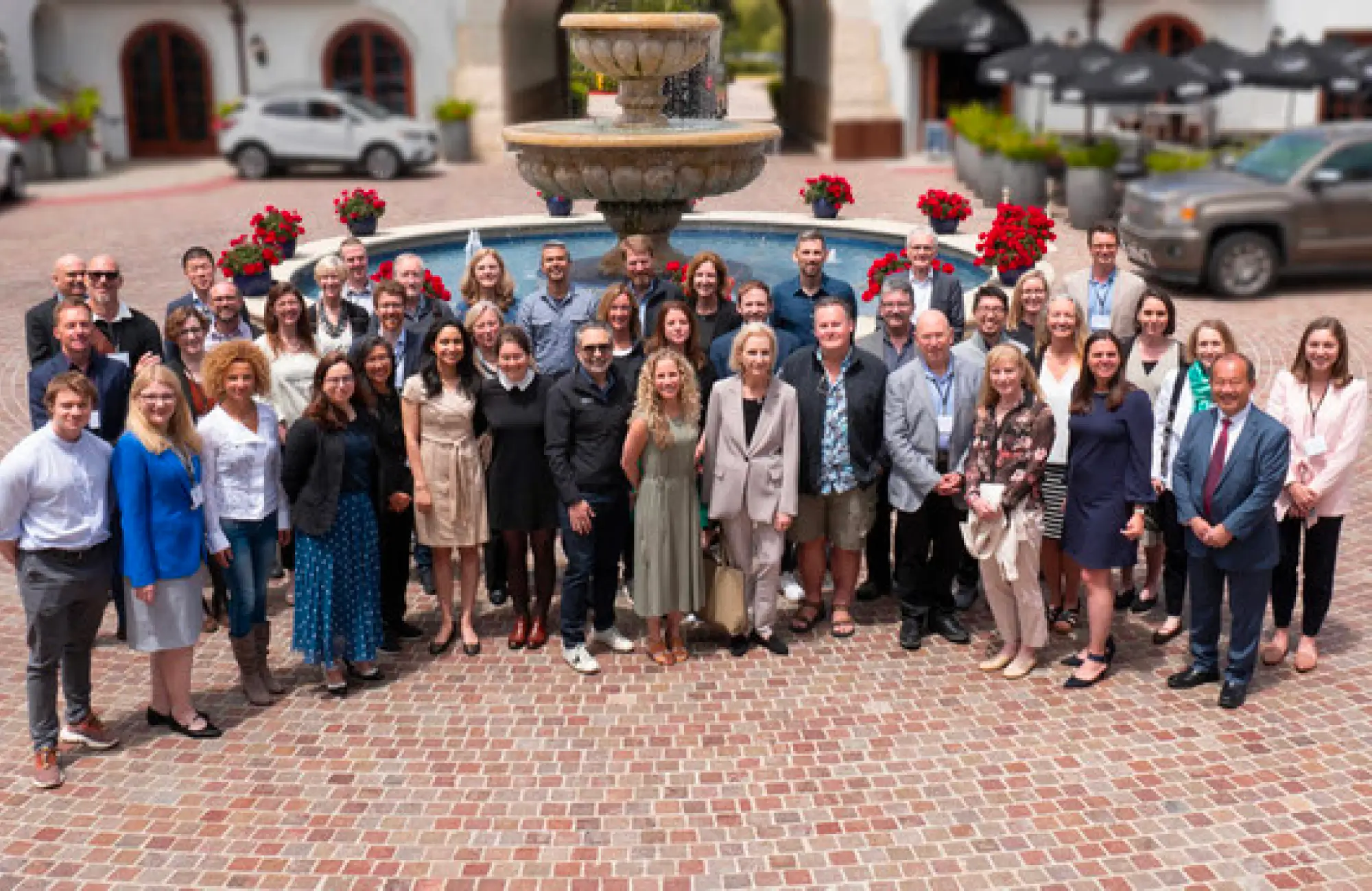 A huge group of people standing in front of a big water fountain